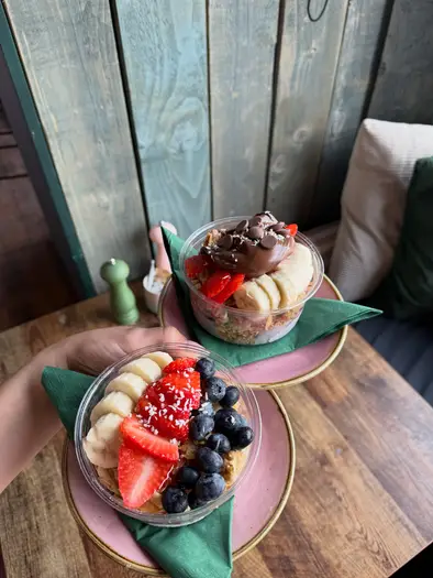 Two of Layla's Lounge açai bowls, topped with fresh fruit and chocolate